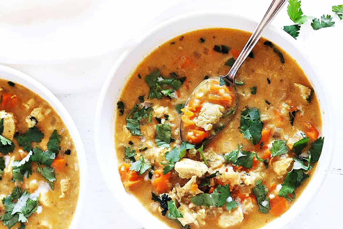 chicken mulligatawny soup in white bowl with spoon