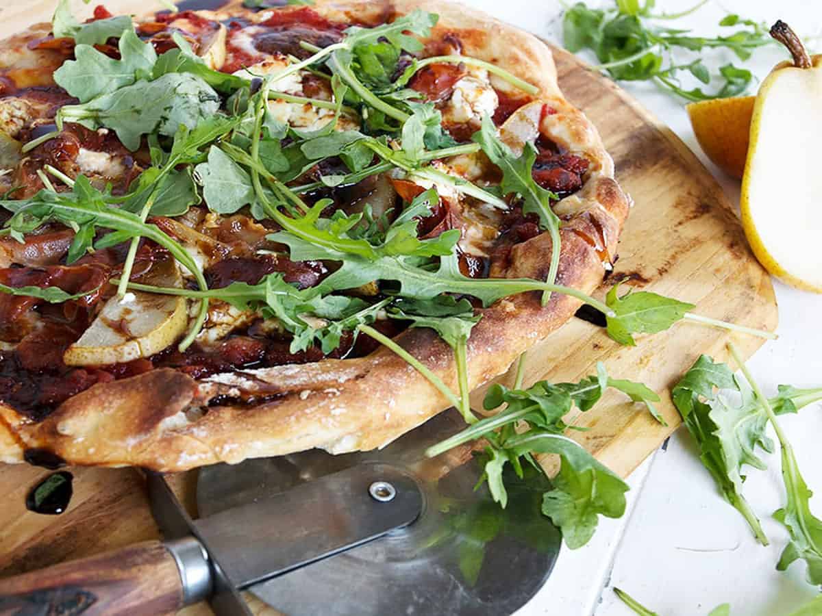 pear prosciutto pizza on pizza peel