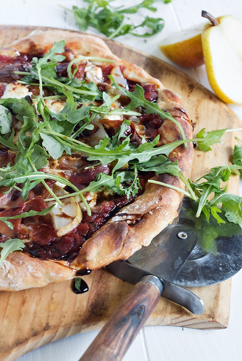 pear prosciutto pizza on a pizza peel