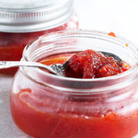red pepper jam in jar with spoon