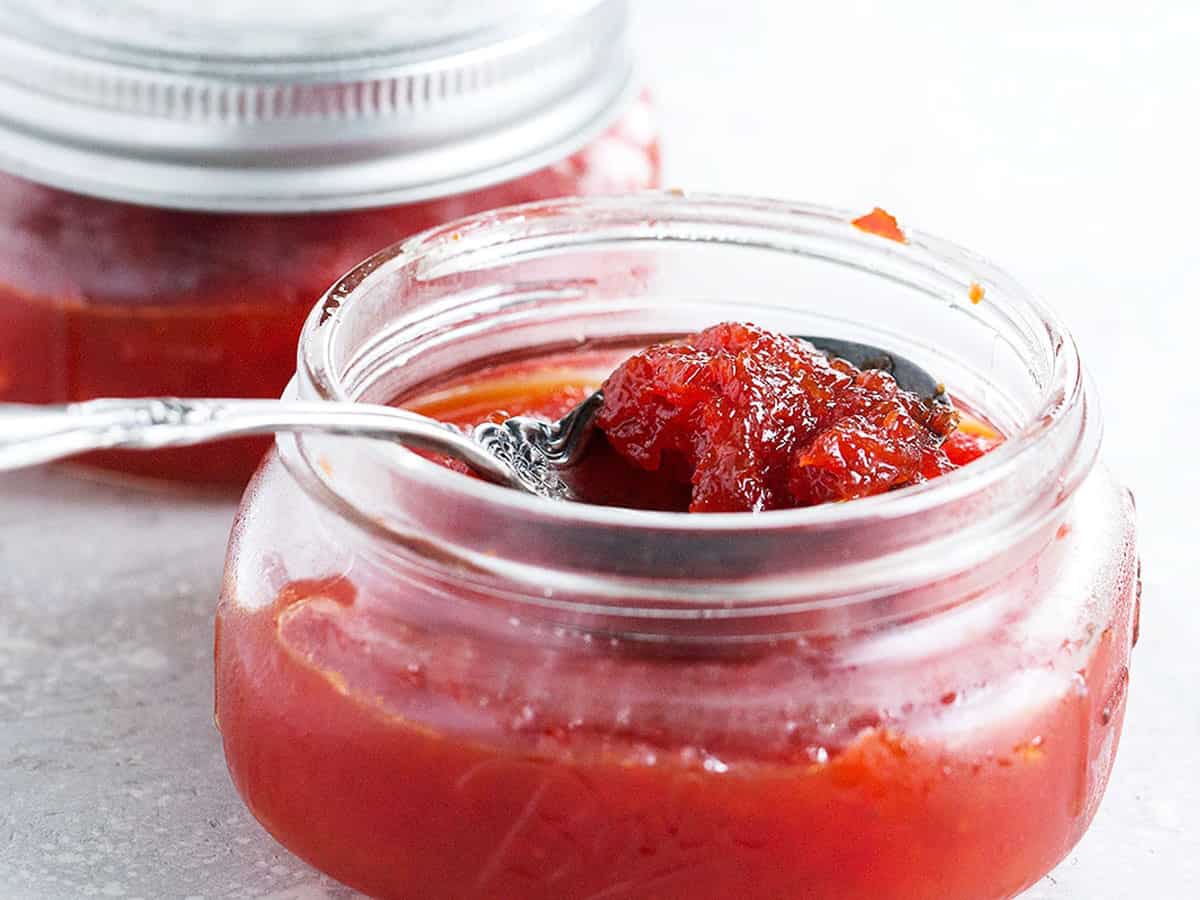 red pepper jam in jar with spoon