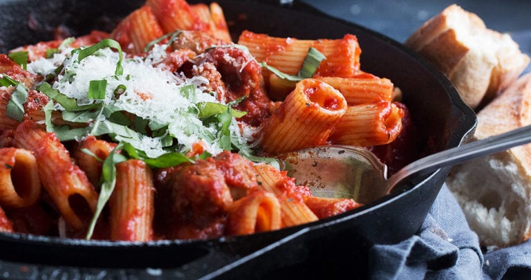 pasta with sausage tomato sauce in cast iron skillet
