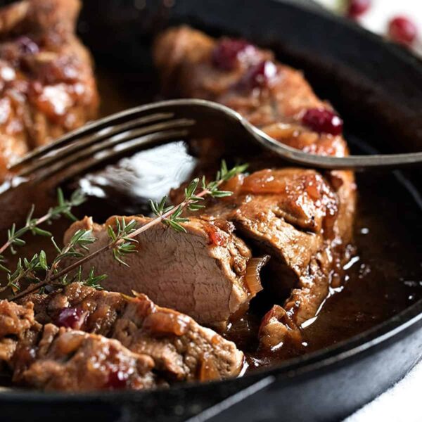 cranberry balsamic pork tenderloin sliced in cast iron skillet