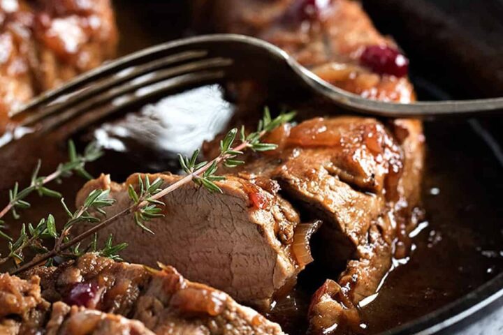 cranberry balsamic pork tenderloin sliced in cast iron skillet