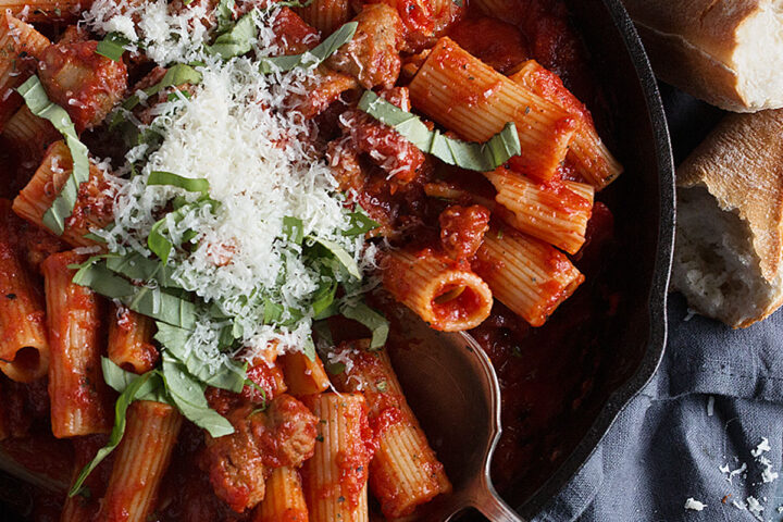 Italian Sausage Pasta in skillet with bread on the side