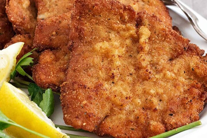 pork schnitzel on plate with lemon slices