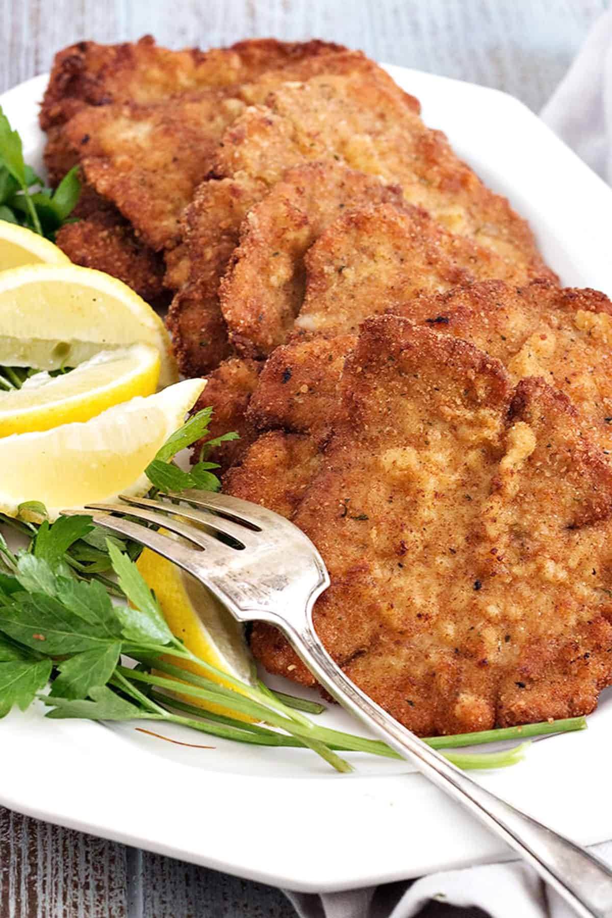 pork schnitzel on plate with lemon slices