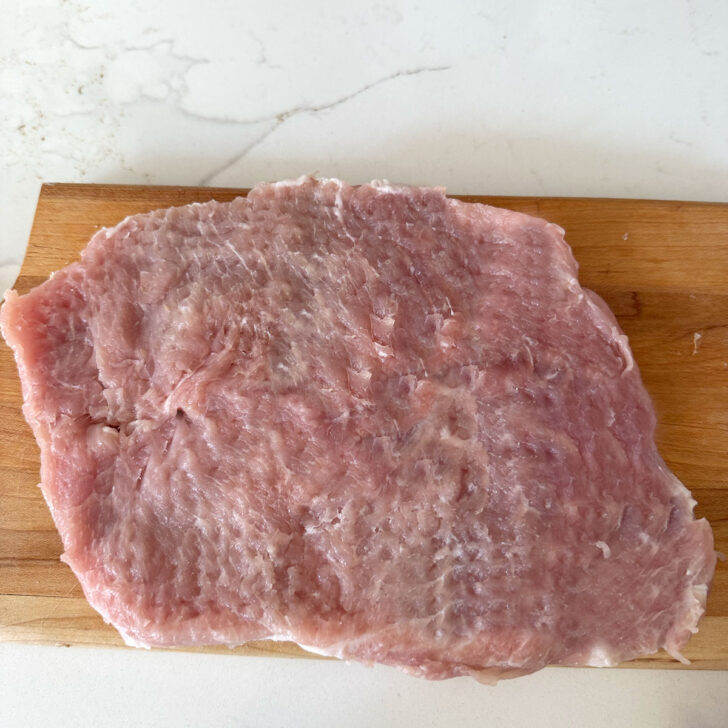 Boneless pork loin chop after being pounded thin.