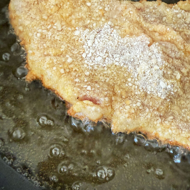 Frying the schnitzel in hot oil.