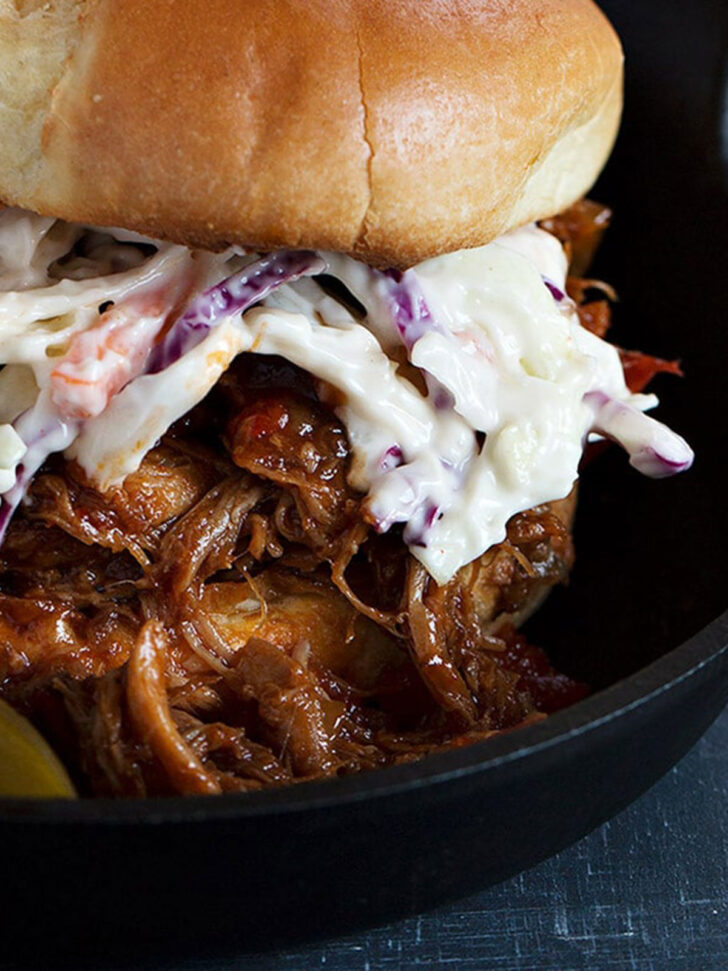 Slow cooker pulled pork on a sandwich with coleslaw.