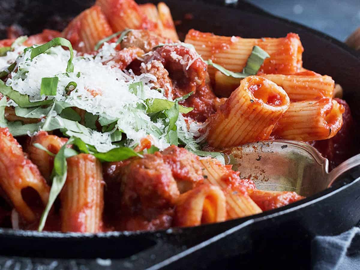 pasta with sausage in small skillet with spoon
