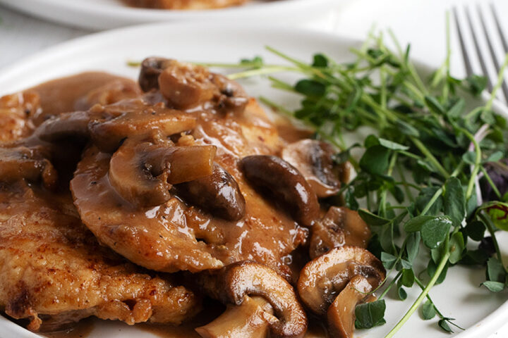 Chicken Marsala plated with greens.