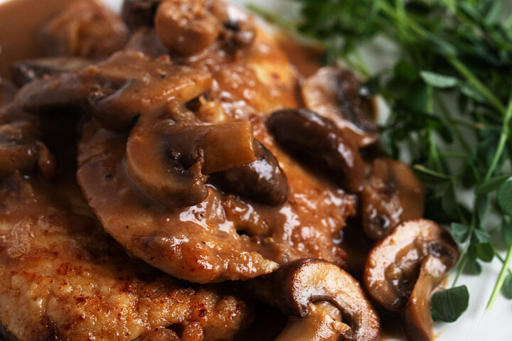 classic chicken marsala on plate with greens
