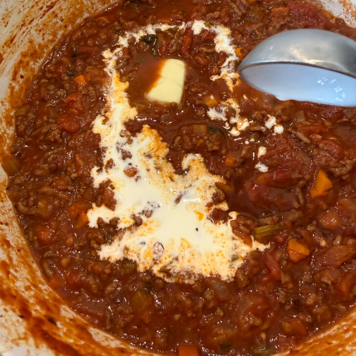Finishing the classic Italian meat sauce with butter and cream.