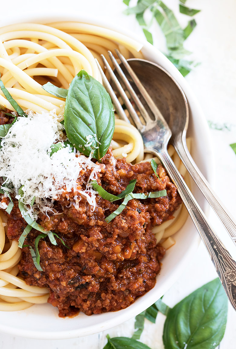 italian meat sauce with pasta in white bowl