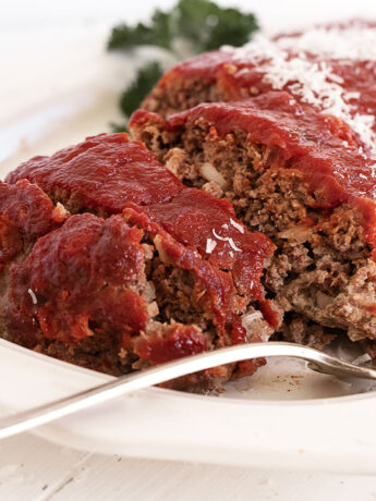 classic meatloaf with tomato topping sliced on platter