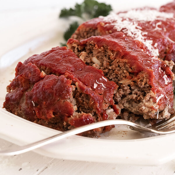 classic meatloaf with tomato topping sliced on platter
