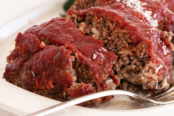 classic meatloaf with tomato topping sliced on platter