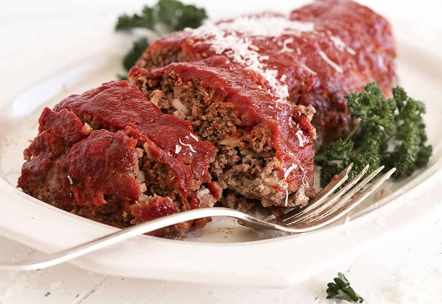 classic meatloaf with tomato topping sliced on platter