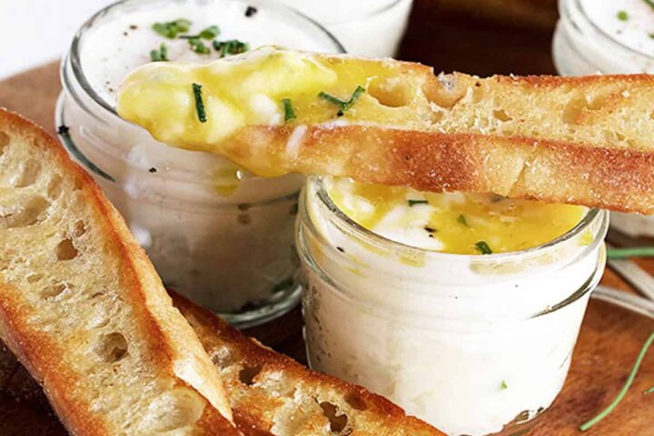 coddled eggs in small jars with mashed potatoes