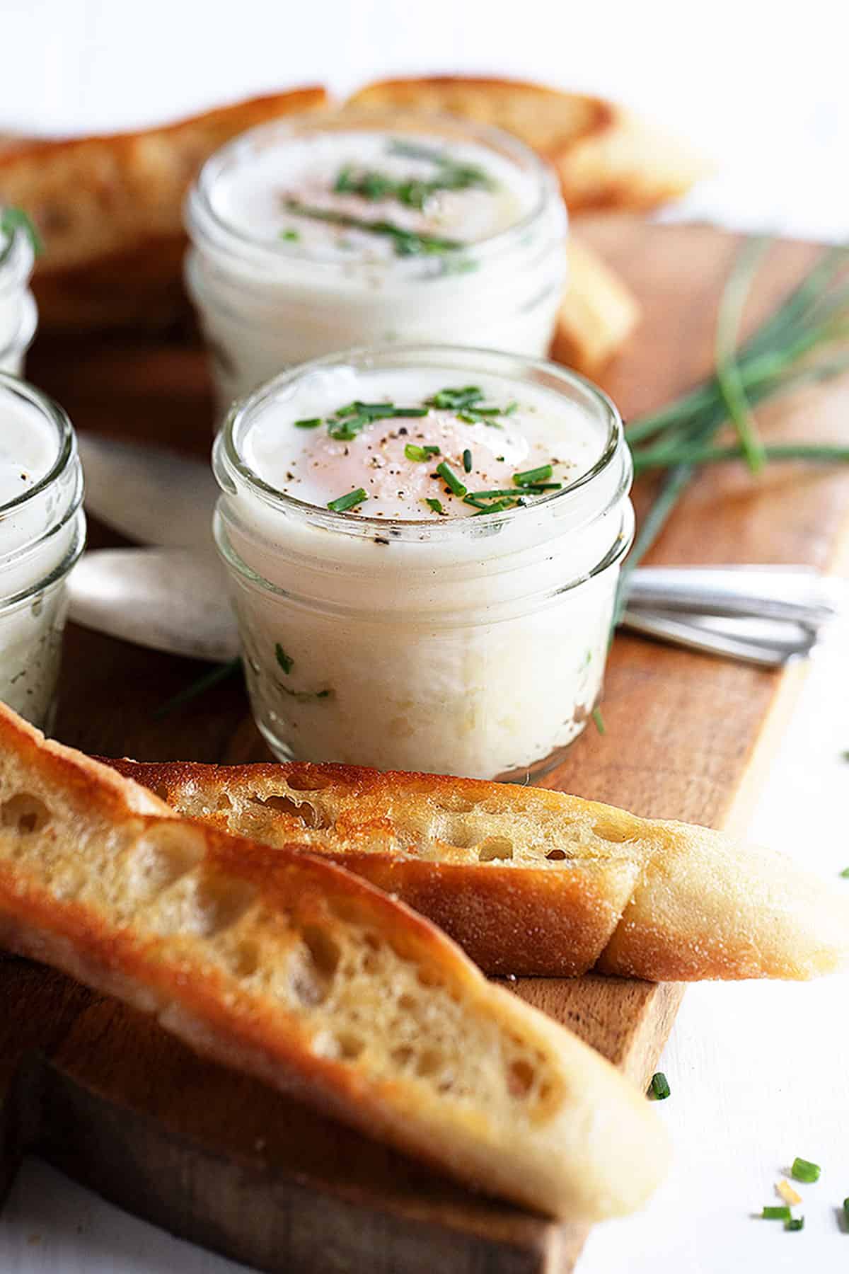 coddled eggs in small jars with mashed potatoes
