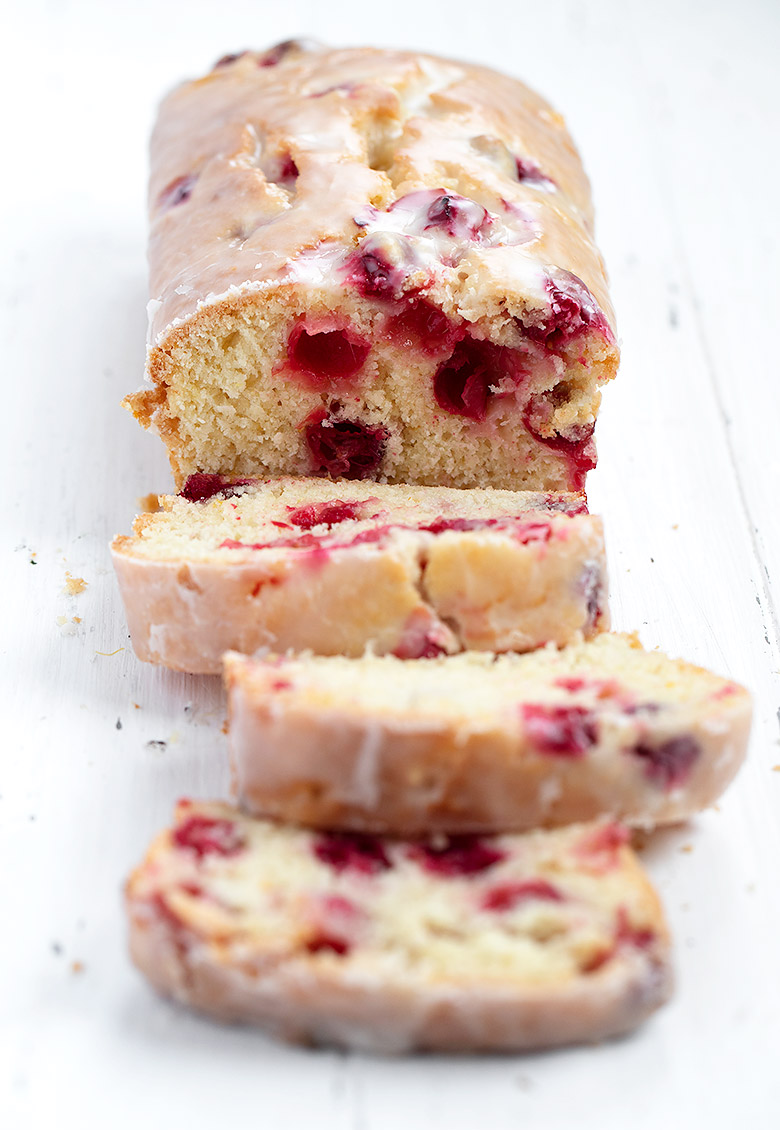 cranberry orange loaf sliced on white background