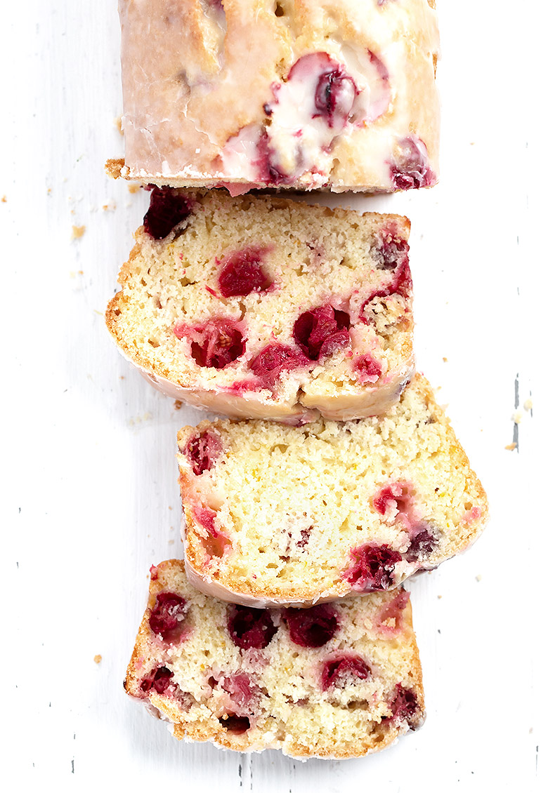 cranberry orange loaf sliced on white background