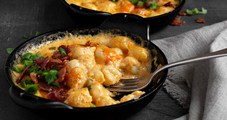 gnocchi and cheese in a small cast iron skillet with fork