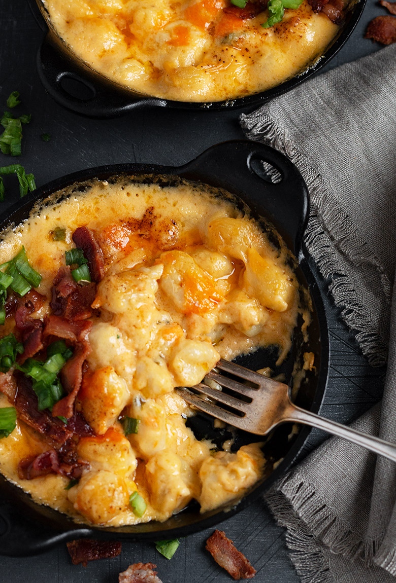 gnocchi and cheese in a small cast iron skillet with fork