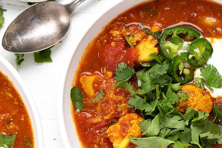 Indian cauliflower soup in white bowls with spoons