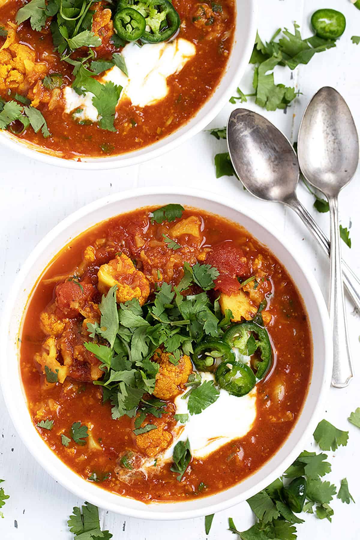 Indian cauliflower soup in white bowls with spoons