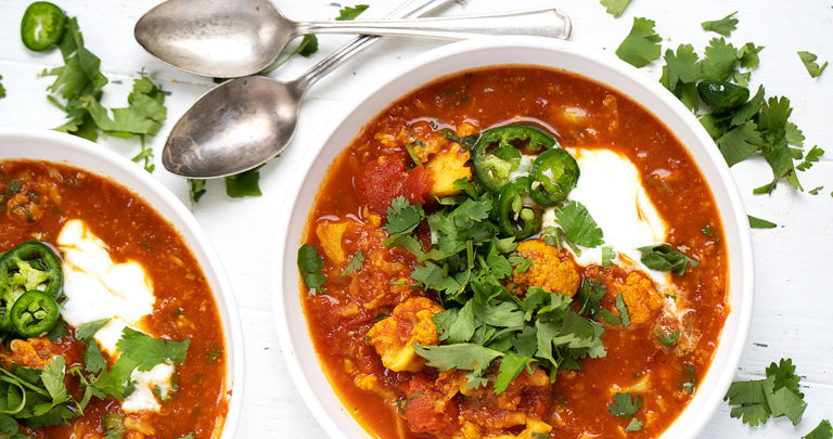 Indian-spiced cauliflower tomato soup in a white bowl