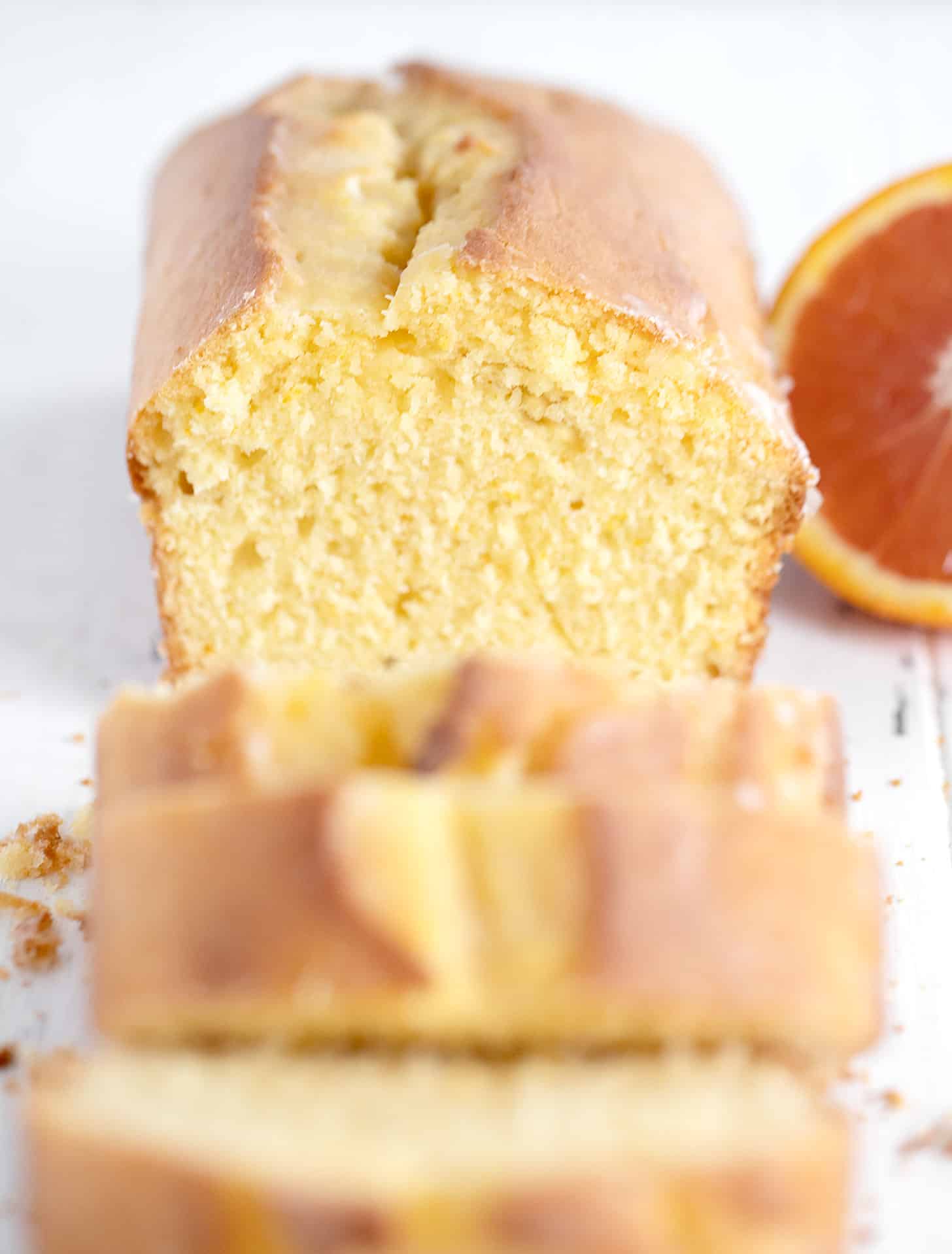 orange pound cake loaf sliced with halved orange