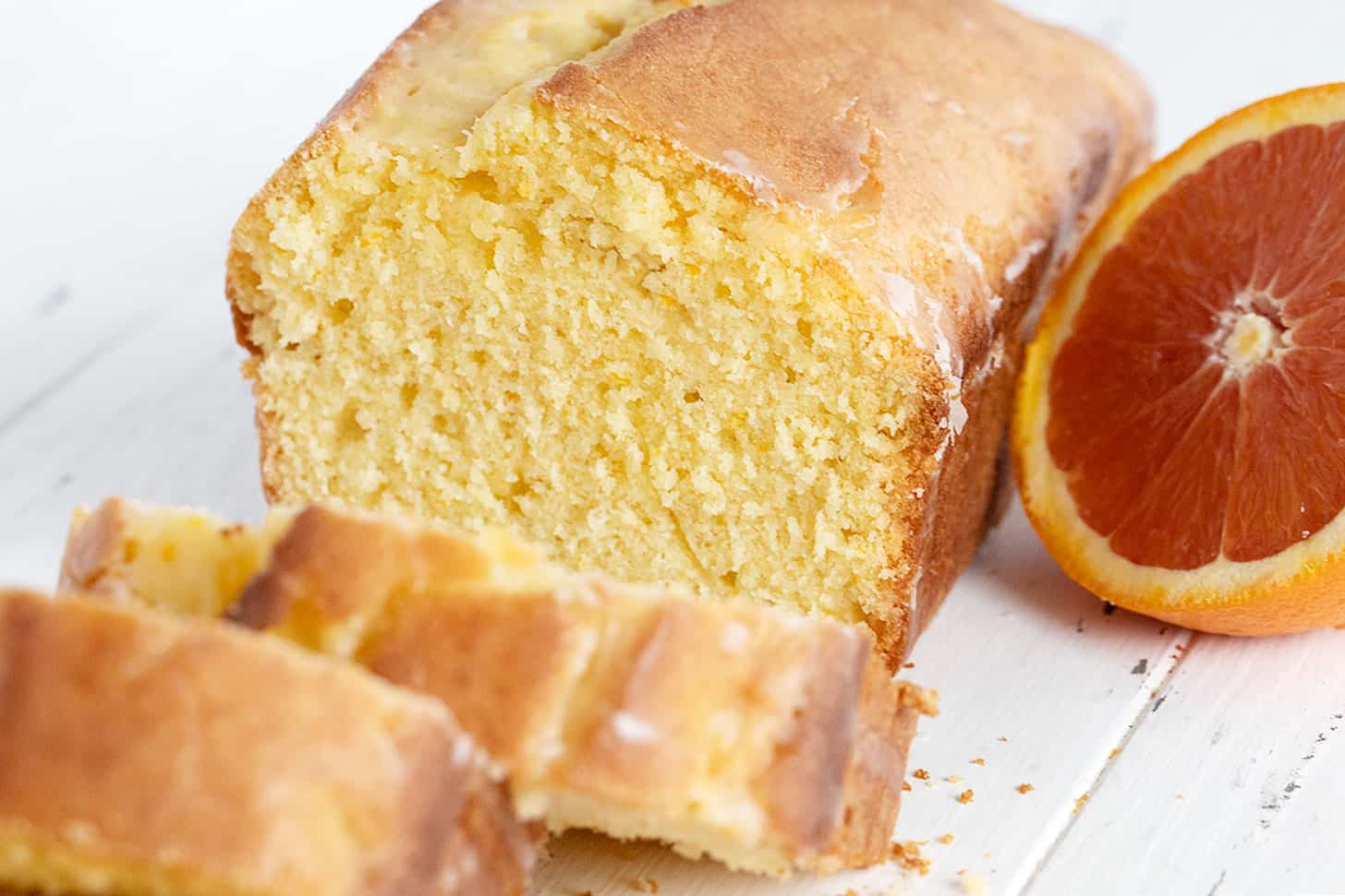 orange pound cake loaf sliced with halved orange