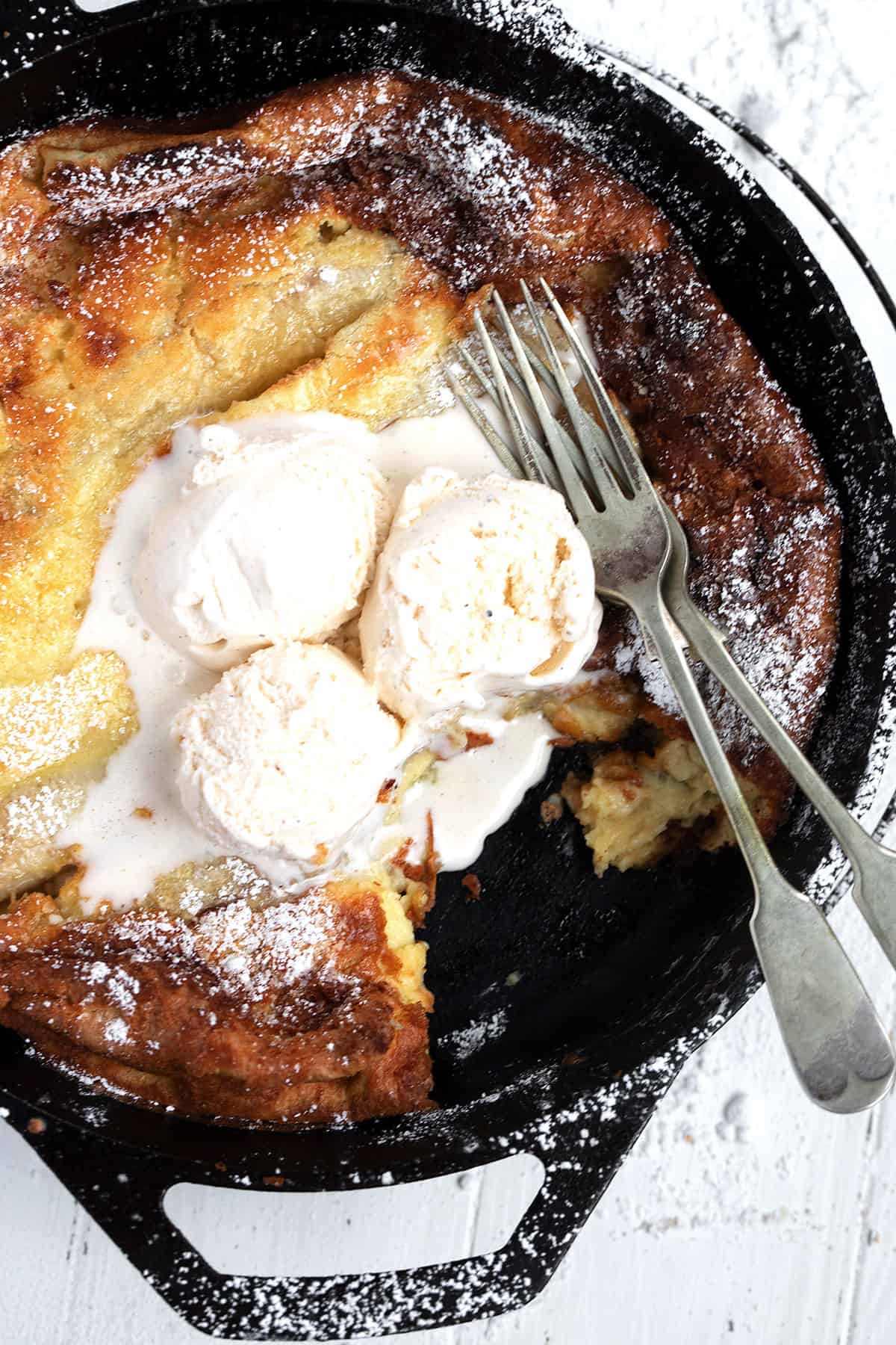 bananas foster Dutch baby pancake in skillet with ice cream