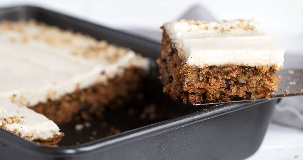 carrot sheet cake in pan with slice out