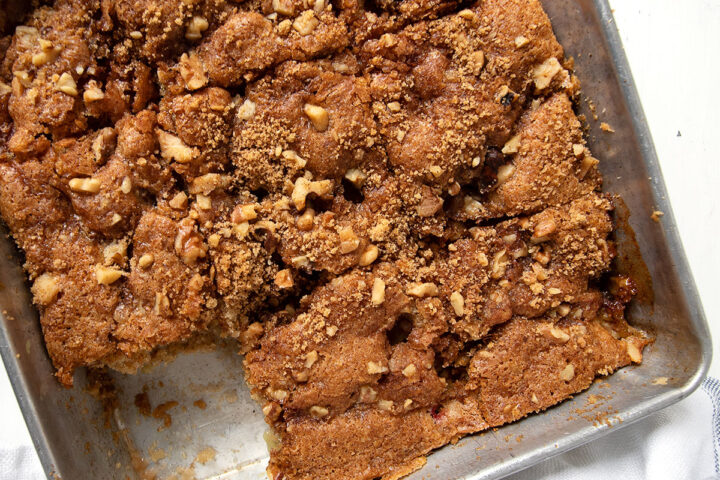 old-fashioned rhubarb cake in pan with a piece out