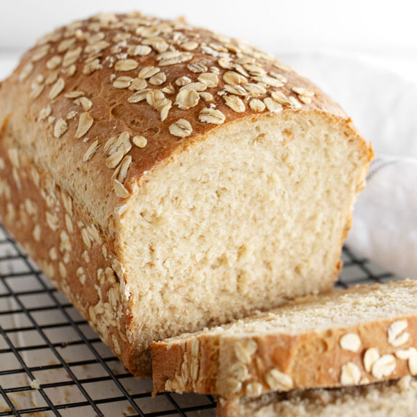 Honey oat bread sliced on cooling rack.