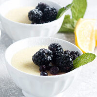 lemon posset in small white bowls with berries on top