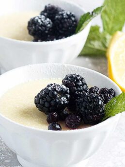 lemon posset in small white bowls with berries on top