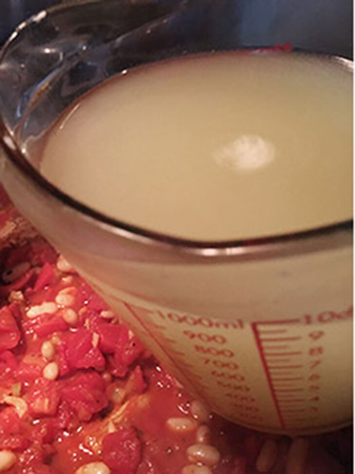 Adding the broth to the pot.