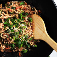 spicy peanut noodles in a cast iron wok