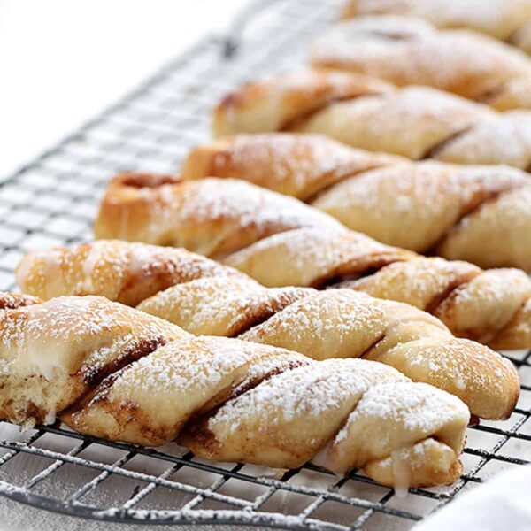 cinnamon twists lined up on a cooling rack in portrait view