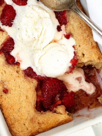 strawberry spoon cake in baking dish with ice cream