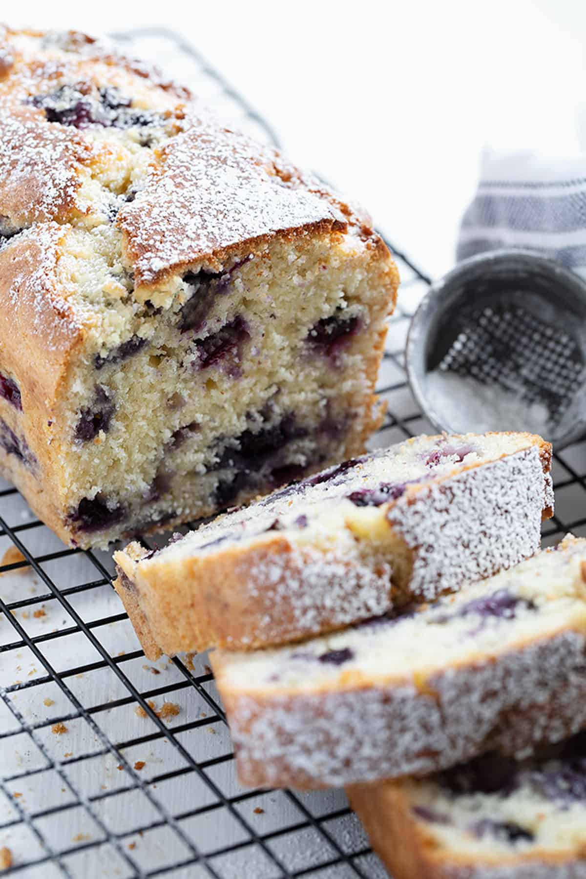 blueberry buttermilk loaf sliced on cooling rack