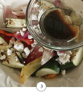 Pouring the balsamic vinaigrette over the grilled vegetables.
