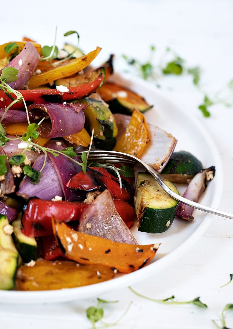 grilled vegetable salad on white plate portrait view