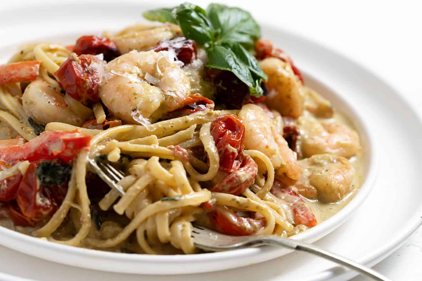 pasta with shrimp and pesto on plate with fork