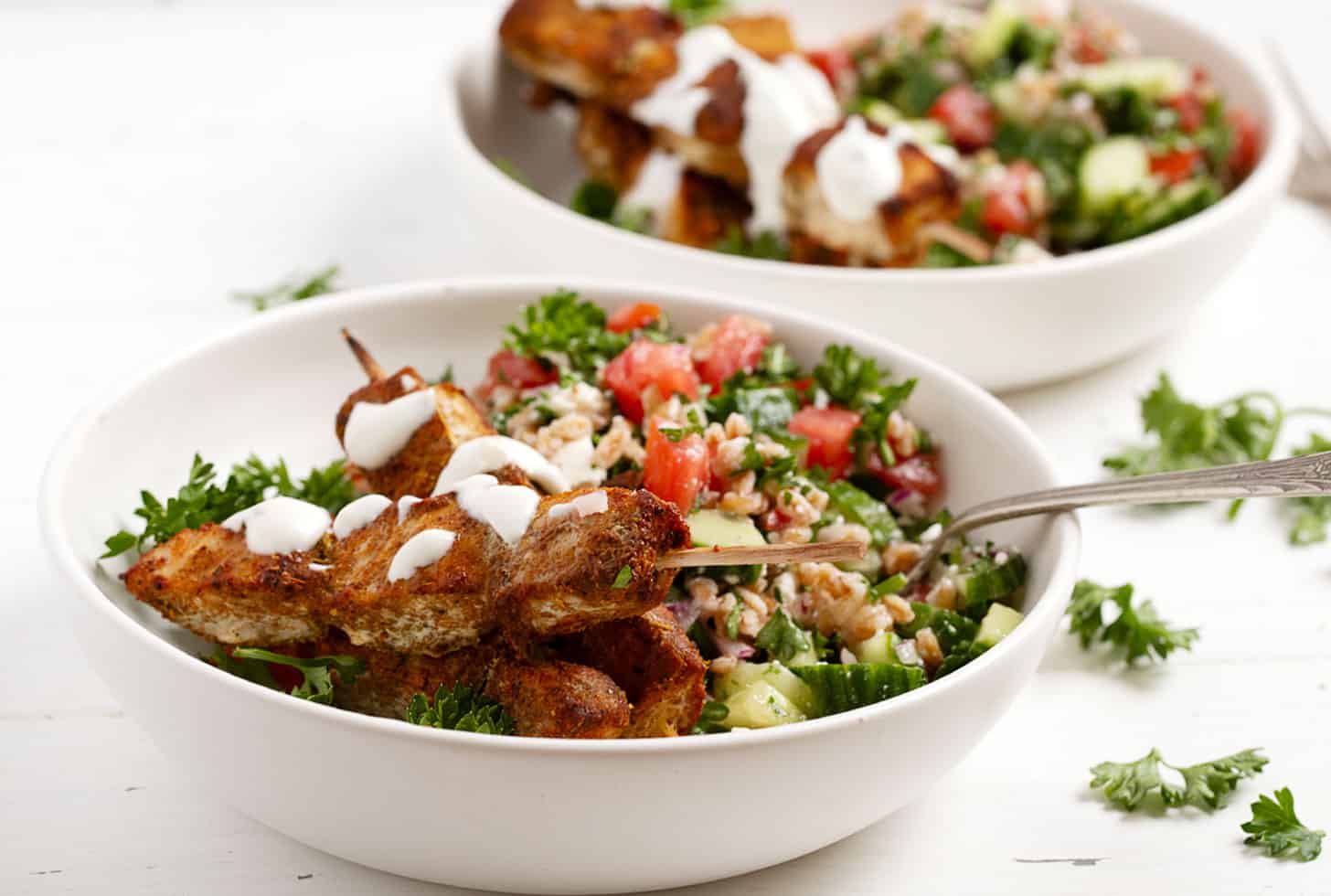 Chicken shawarma skewers served with a grain salad.