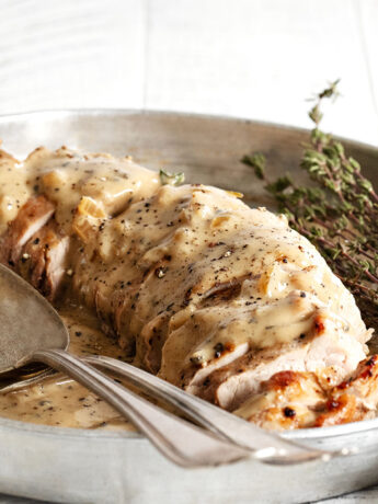 pork tenderloin with peppercorn gravy on platter